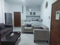 a living room with two couches and a kitchen at Cozy Home 2 in Amman