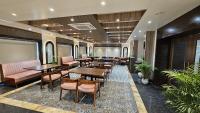 瓦拉纳西Hotel Sainik Grand的大堂内的餐厅,配有桌椅