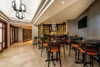 a restaurant with black tables and chairs and a bar at Hilton Ponce Golf & Casino Resort in Ponce