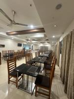 a row of tables and chairs in a restaurant at Hotel Gokulam Grand in Pithāpuram