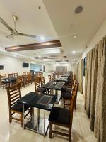 a row of tables and chairs in a room at Hotel Gokulam Grand in Pithāpuram
