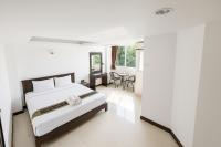 a white bedroom with a bed and a table at Chaweng grand view point in Koh Samui 