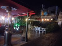 Un patio al aire libre con mesas y sillas por la noche. en Casa Alto de la Virgen DeMaiz, en Choachí