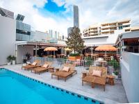 una piscina de hotel con sillas y un árbol de Navidad en Bunk Brisbane, en Brisbane
