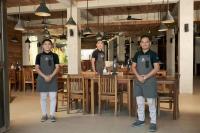 três pessoas à frente de uma mesa num restaurante em San Juan Surf Resort La Union em San Juan