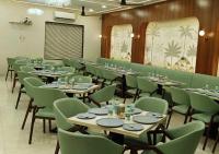 a dining room with tables and green chairs at Hotel Amit Palace Bhimashankar in Ghoda