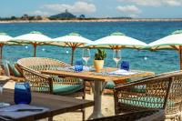 a table with wine glasses and chairs on the beach at Is Molas Villas in Pula