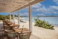 a row of tables and chairs on a beach at Is Molas Villas in Pula