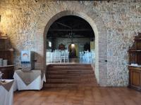a room with an archway with white tables and chairs at Allegroitalia Torre Artale Palermo in Trabia