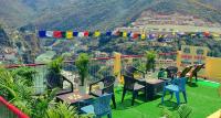 balcón con sillas y mesas y vistas a la montaña en Sangam View Home stay, en Devaprayāg