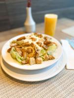 a plate of food with a salad and a glass of orange juice at Promenade Soho Campos dos Goytacazes - OFICIAL in Campos dos Goytacazes