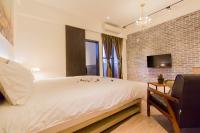 a bedroom with a white bed and a brick wall at Book 5 in Dongshan