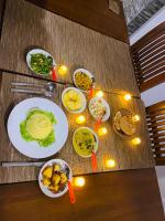 een tafel met borden met voedsel erop met verlichting bij Sithuka Villa Bentota in Bentota