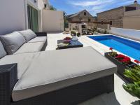 a patio with a couch and a swimming pool at Modern Villa in Povlja with Pool in Povlja