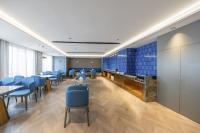 a waiting room with blue chairs and tables at Mido Hotel - Nanning Anji Wanda Plaza Branch in Nanning