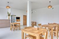 a dining room with wooden tables and chairs at Kelingking Green Village in batumadeg