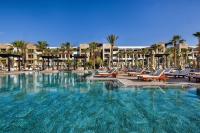 a large swimming pool with lounge chairs and apartments at Hotel Riu Palace Tikida Agadir - All Inclusive in Agadir