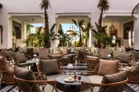 a lobby with tables and chairs and palm trees at Hotel Riu Palace Tikida Agadir - All Inclusive in Agadir