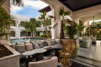 a patio with a couch and tables and a pool at Hotel Riu Palace Tikida Agadir - All Inclusive in Agadir