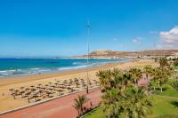 a beach with chairs and palm trees and the ocean at Hotel Riu Palace Tikida Agadir - All Inclusive in Agadir