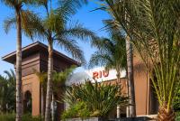 a resort with palm trees in front of a building at Hotel Riu Palace Tikida Agadir - All Inclusive in Agadir
