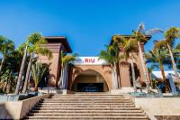 an entrance to a building with palm trees and stairs at Hotel Riu Palace Tikida Agadir - All Inclusive in Agadir