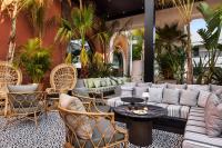 a patio with couches and tables and palm trees at Hotel Riu Palace Tikida Agadir - All Inclusive in Agadir