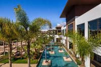 an infinity pool with palm trees in front of a building at Hotel Riu Palace Tikida Agadir - All Inclusive in Agadir