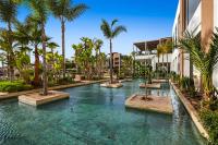 a swimming pool with palm trees in a resort at Hotel Riu Palace Tikida Agadir - All Inclusive in Agadir