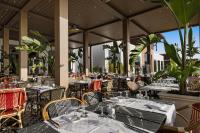 an empty restaurant with tables and chairs and plants at Hotel Riu Palace Tikida Agadir - All Inclusive in Agadir