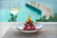 a plate of food next to a glass of wine at Impression Isla Mujeres by Secrets - Adults Only - All Inclusive in Isla Mujeres