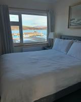a bedroom with a large bed and a large window at Oliver&#39;s Seafood Bar in Cleggan
