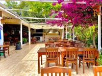 een restaurant met houten tafels en stoelen en paarse bloemen bij UMAYRA OTEL in Bodrum City
