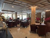 un comedor con mesas, sillas y flores en Hotel Sinar 1, en Sedati