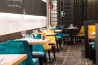 Un restaurante con mesas y sillas con copas de vino. en Best Western Premier Hotel de la Paix, en Reims