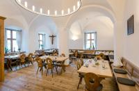 un restaurante con mesas y sillas de madera y una gran lámpara de araña en Kloster Seeon, en Seeon-Seebruck