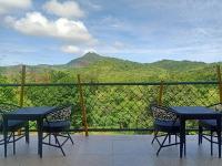 een balkon met 2 stoelen en uitzicht op een berg bij Escape Boutique Hotel in Puerto Princesa City