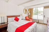 Una habitación de hotel con una cama roja y blanca y una ventana. en OYO Inn Kernersville, en Kernersville