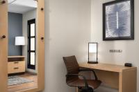 a room with a chair and a desk with a mirror at Hyatt Place Atlanta Airport North in Atlanta