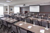 a conference room with tables and chairs and a screen at Hyatt Place Atlanta Airport North in Atlanta