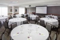 a conference room with white tables and chairs and a screen at Hyatt Place Atlanta Airport North in Atlanta