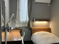 Un dormitorio con una cama, un escritorio y una lámpara. en Atto Business Hotel Ichinoseki, en Ichinoseki