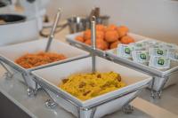 Tres bandejas de comida en un mostrador con naranjas. en Act Hotel, en Daegu