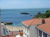 a view of a beach with people in the water at Hôtel Les Alizés in Biarritz