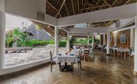 a restaurant with tables and chairs in a building at Exploreans Malaika Villas and Beach Club in Malindi