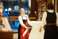 Una mujer está ayudando a otra mujer a ponerse su vestido de novia. en Sonnenhof Resort Bayerischer Wald, en Lam