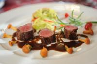 un plato de comida con carne y salsa. en Sonnenhof Resort Bayerischer Wald, en Lam