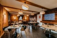 Un restaurante con paredes de madera y mesas y sillas. en Hôtel Restaurant La Ferme de Cupelin, en Saint-Gervais-les-Bains
