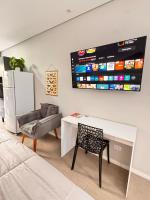 a living room with a table and a chair and a tv at La Estancia Residencial in Iguape