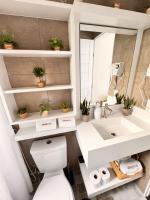 a bathroom with a toilet and a sink at La Estancia Residencial in Iguape